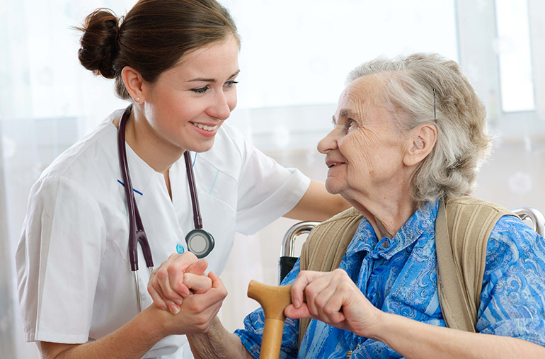 Pflegerin interagiert mit einer Seniorin